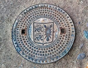 manhole cover, sieldeckel, coat of arms of schleswig-holstein, metal, split, on the left, two lions, right holstein nettle leaf, cover, sewage system, wastewater, gullideckel, plate, custom-made